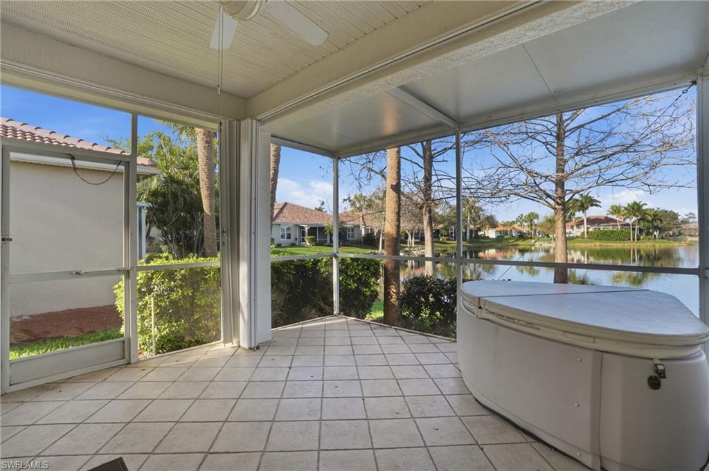 Sunroom / solarium featuring a ceiling fan, a residential view, and a water view - Virtually Edited Image
