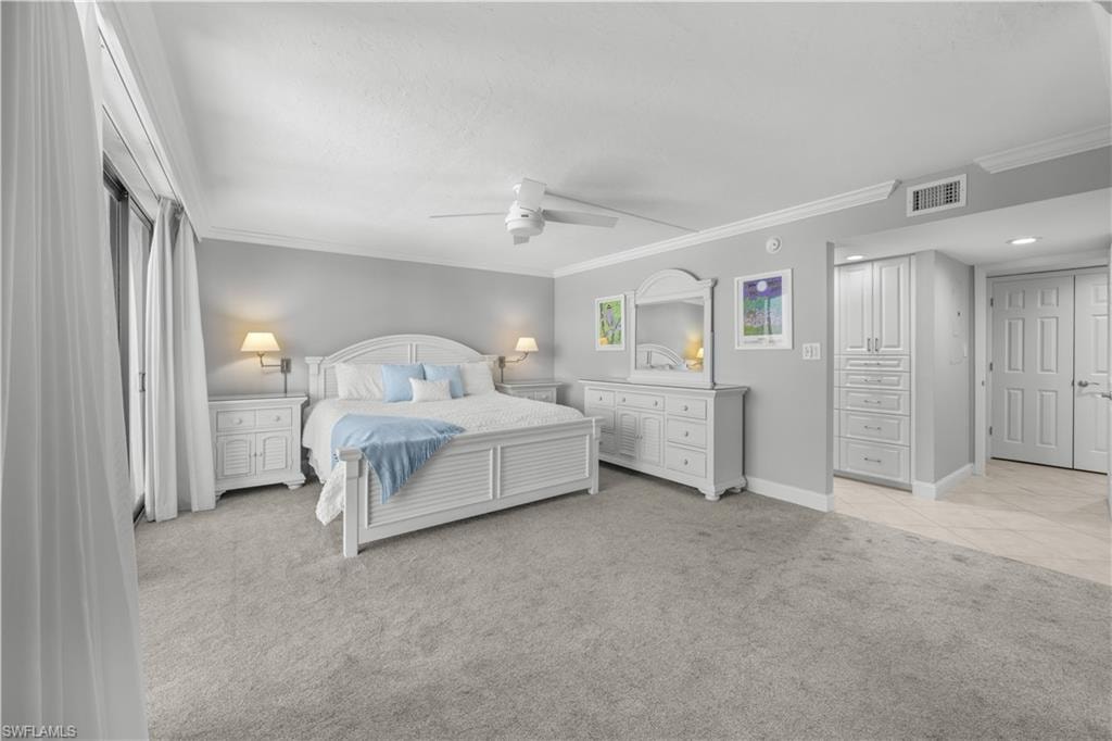 Primary bedroom with light gray carpet and white furnishings.