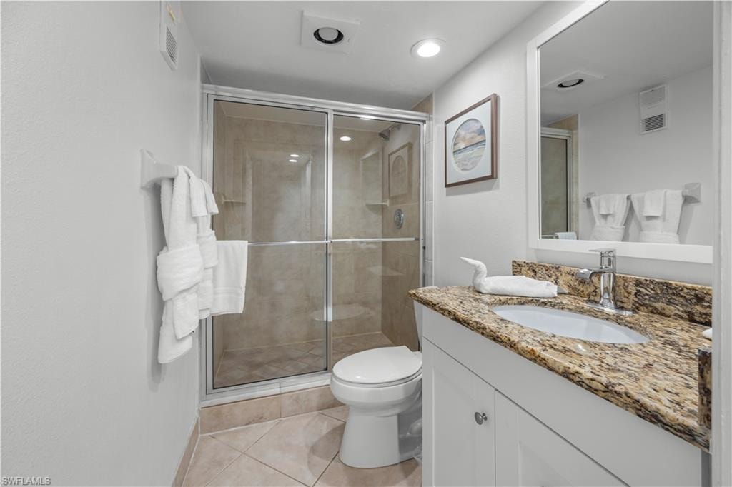 Primary bathroom with white cabinets and granite countertops.