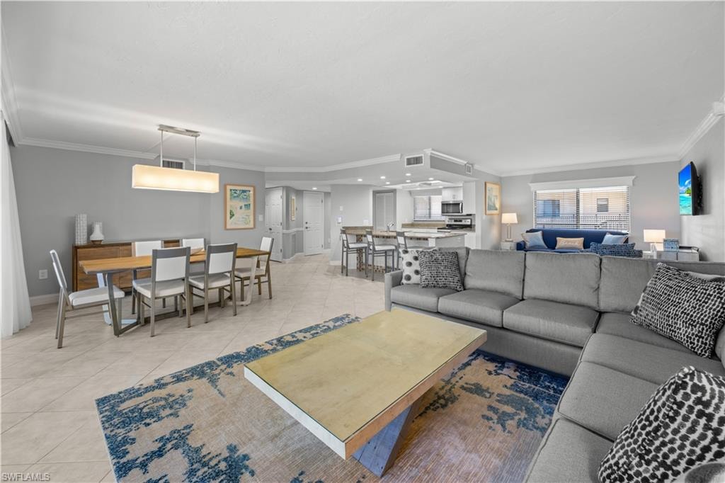 Living room with light furnishings and tile flooring.