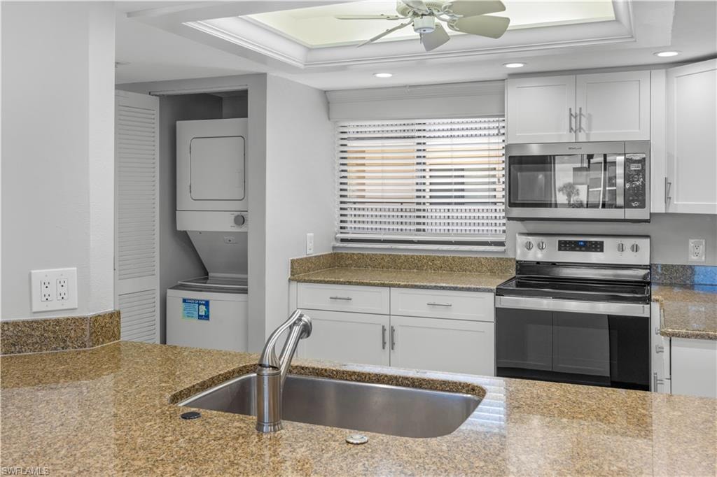 view from bar into the kitchen, stackable washer/dryer, stainless appliances.