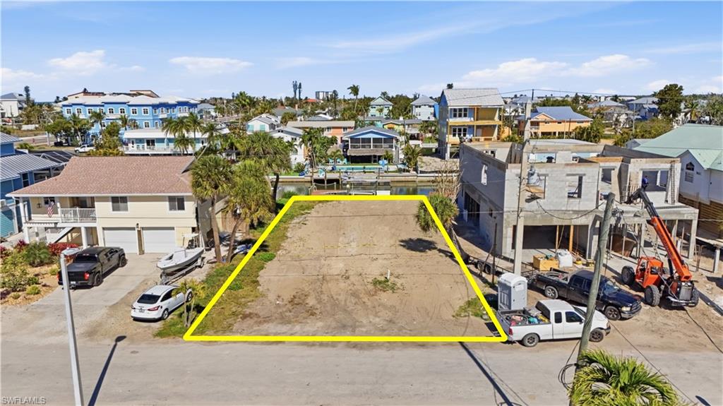 Aerial perspective of canal lot with property boundaries highlighted - Virtually Edited Image