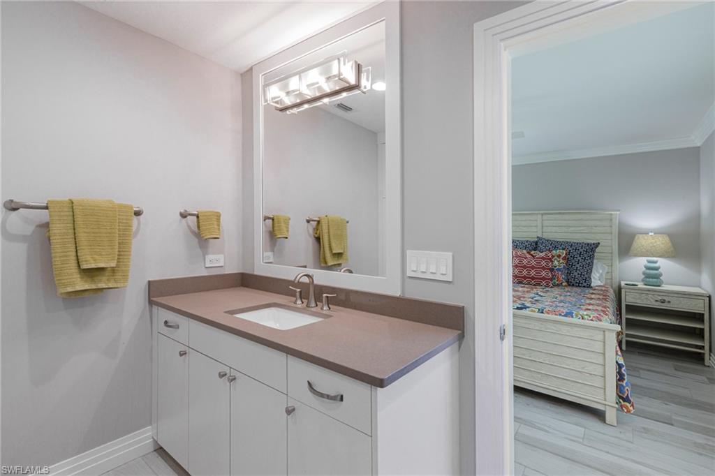Bathroom with ornamental molding, vanity, and hardwood / wood-style floors