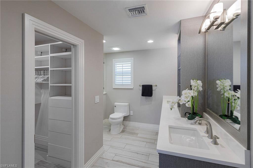 Bathroom featuring dual bowl vanity and toilet
