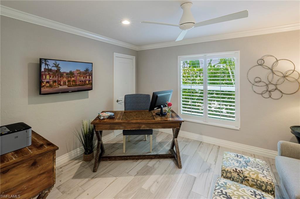 Office area with ceiling fan, light hardwood / wood-style flooring, and ornamental molding
