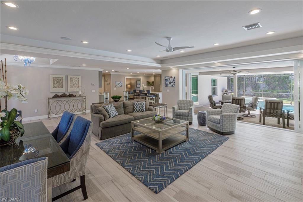 Living room with ceiling fan, light hardwood / wood-style flooring, and crown molding