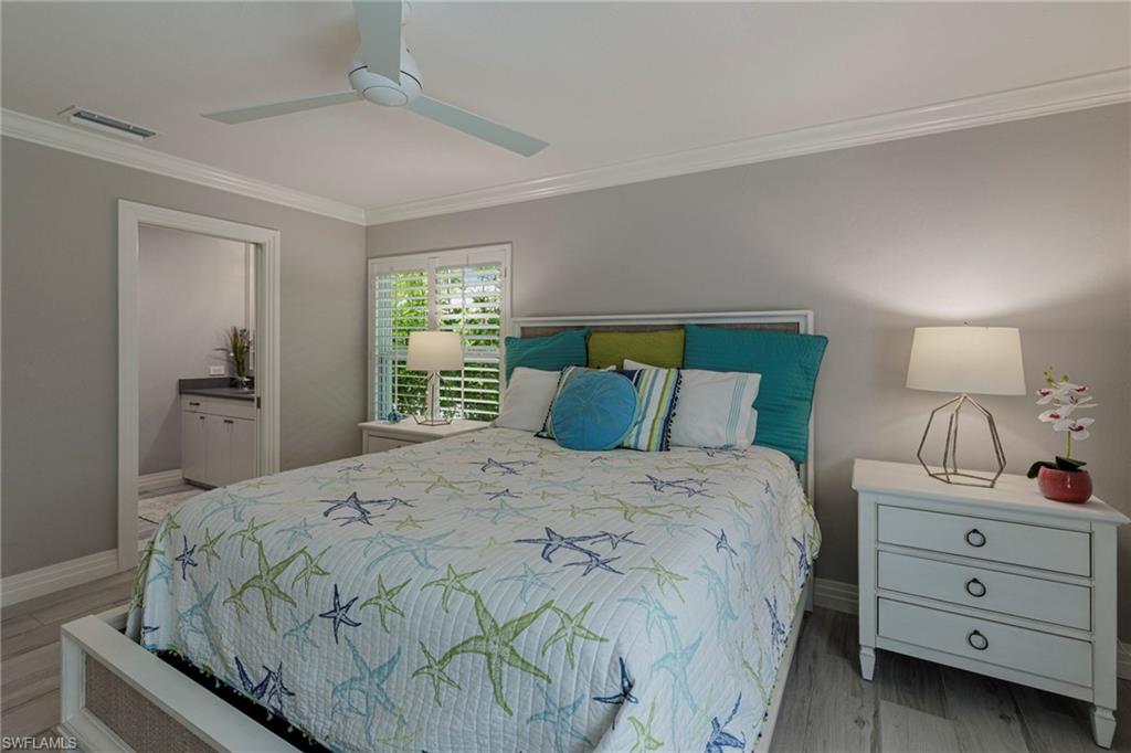 Bedroom with ceiling fan, ornamental molding, connected bathroom, and hardwood / wood-style flooring