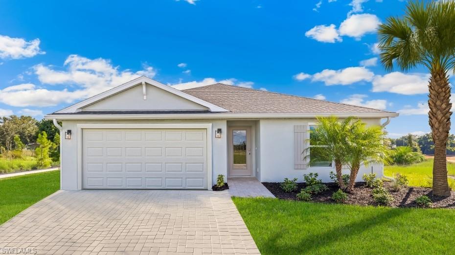 Model home. Ranch-style house with driveway, stucco siding, and a front lawn