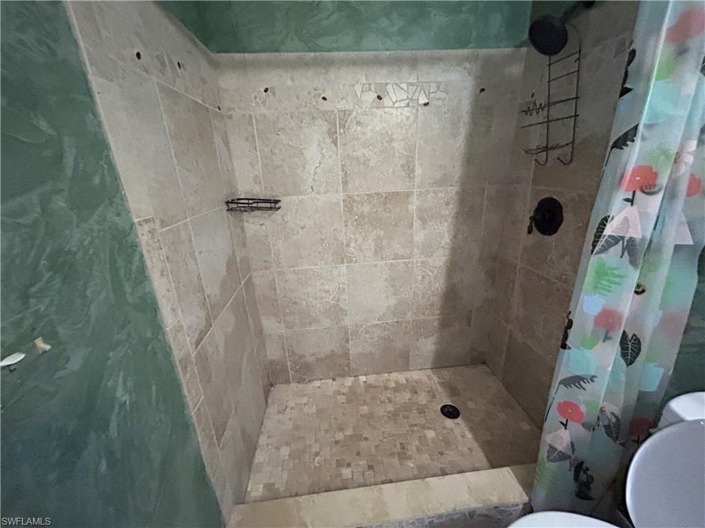 Bathroom featuring a stall shower and toilet