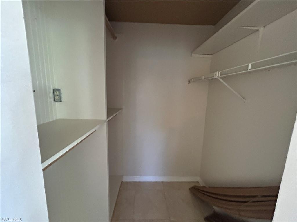 Walk in closet with light tile patterned flooring