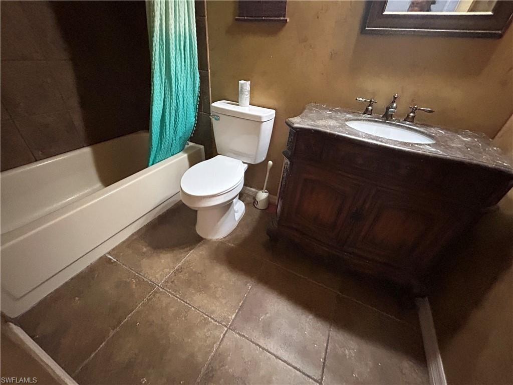 Bathroom featuring vanity, shower / tub combo, and tile patterned floors