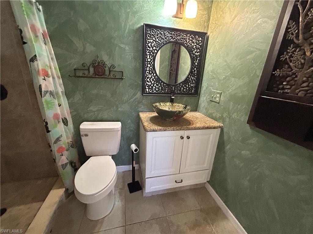 Full bathroom featuring vanity, a shower stall, and light tile patterned floors
