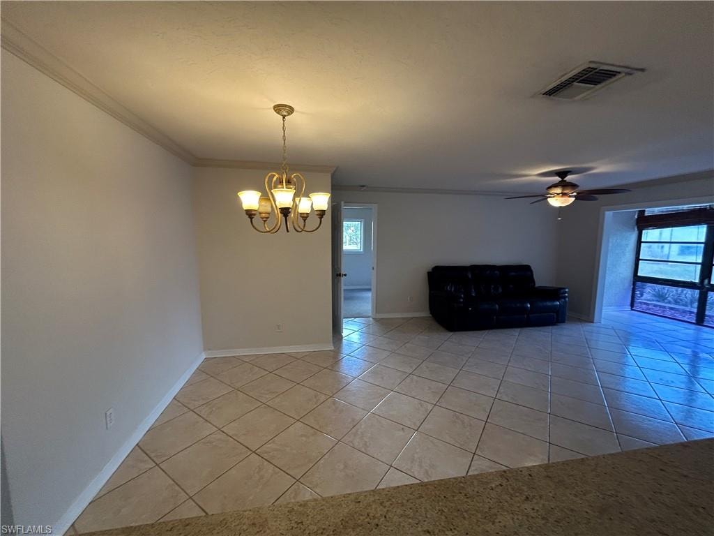 Spare room with ceiling fan, light tile patterned floors, a chandelier, and crown molding