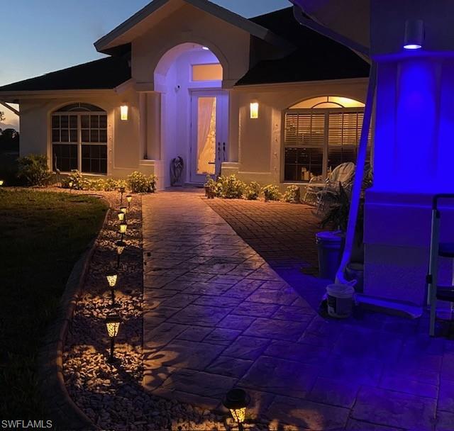 View of exterior entry featuring stucco siding