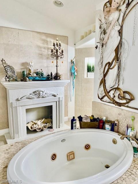 Bathroom featuring a fireplace, a walk in shower, and a tub with jets