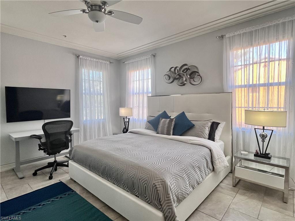 Spacious primary bedroom featuring a King bed, modern furnishings, abundant natural light, and a dedicated workspace with flat-screen TV — the perfect blend of comfort and functionality.