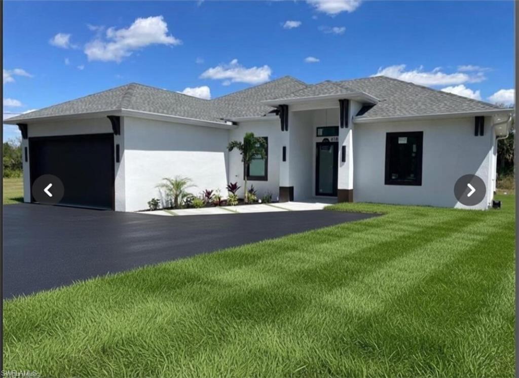 Modern exterior featuring a white stucco facade, black framed windows, a dark shingle roof, a black garage door, and a paved driveway