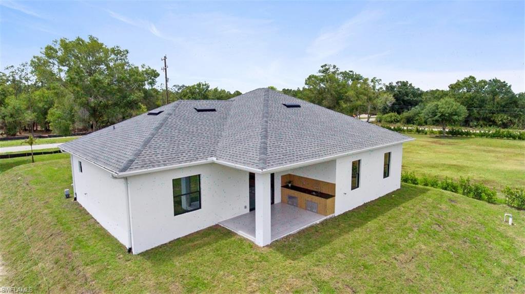 Modern single-story residence featuring a gray shingle roof and white stucco exterior
