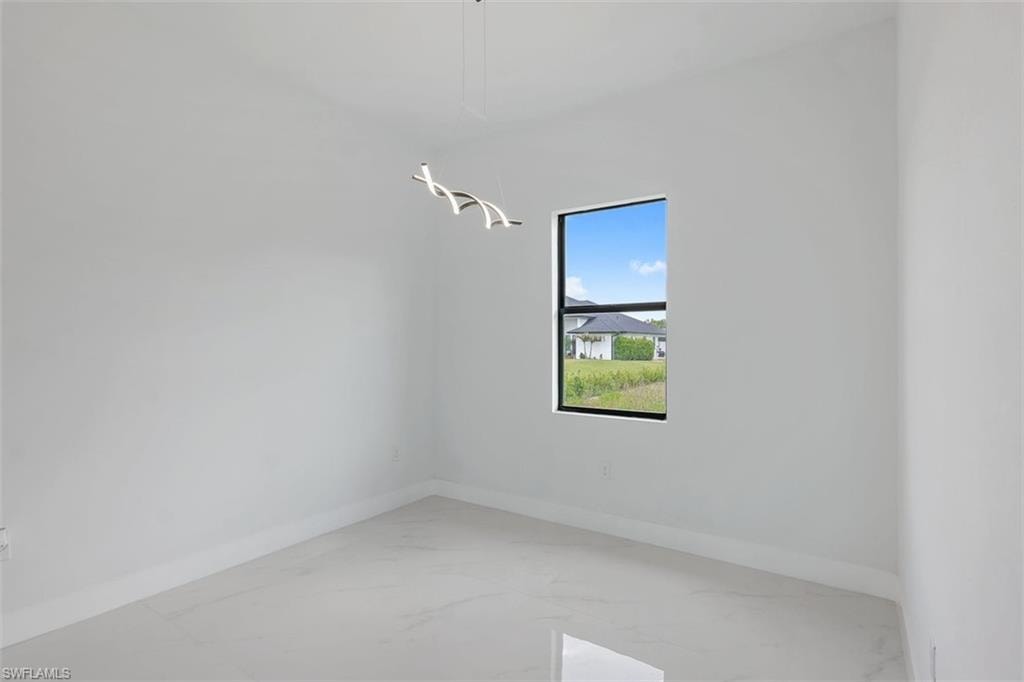 Open room featuring white walls, light-toned tile flooring, and a contemporary ceiling light fixture