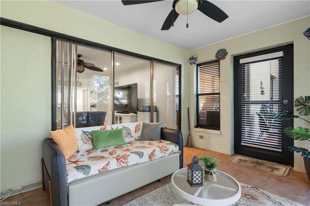 Tiled bedroom featuring a textured wall and ceiling fan