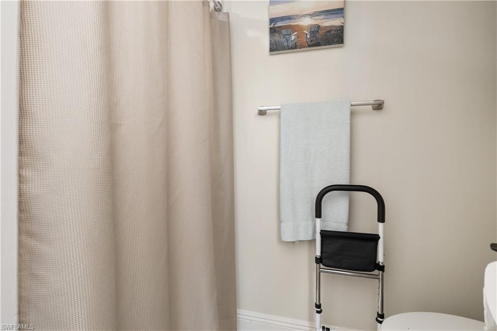Full bath featuring a shower with shower curtain and toilet