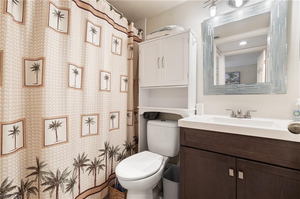 Bathroom featuring vanity, curtained shower, and wallpapered walls