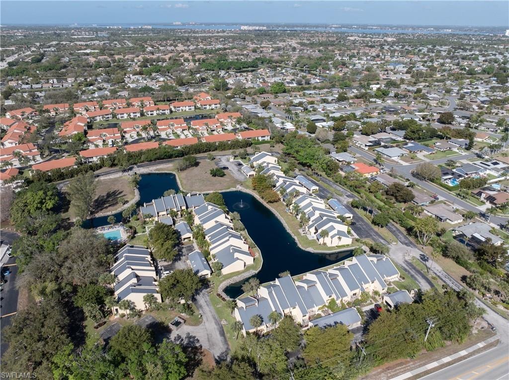 Aerial view of property and surrounding area with a nearby body of water and nearby suburban area