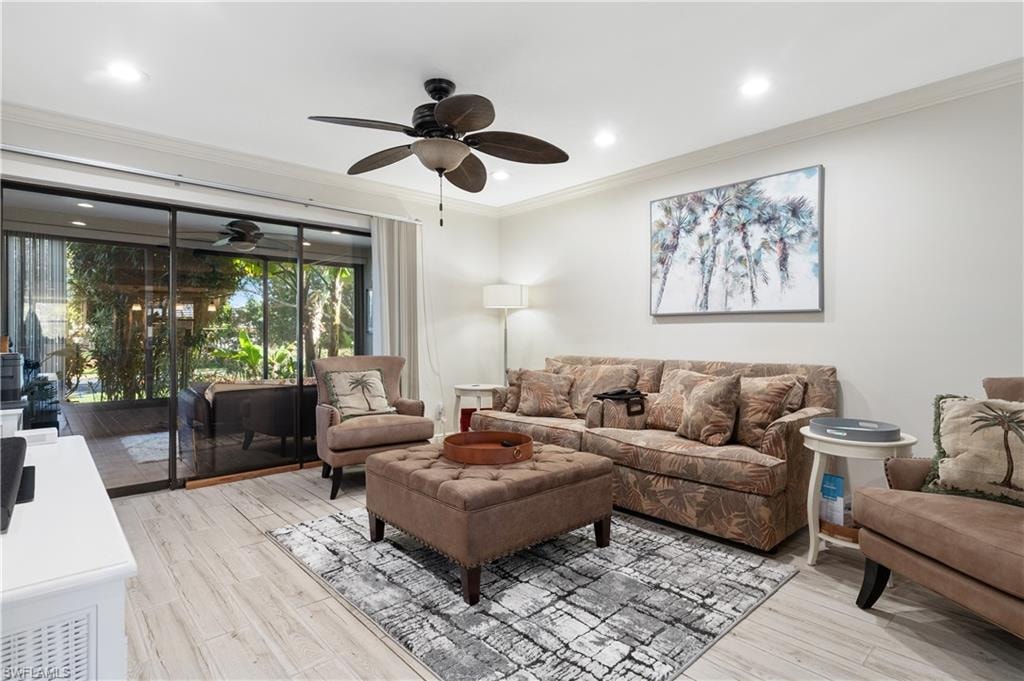 Living room with crown molding, a ceiling fan, light wood-type flooring, and recessed lighting