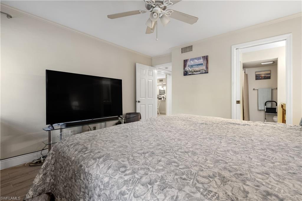Bedroom featuring ornamental molding, wood finished floors, and a ceiling fan
