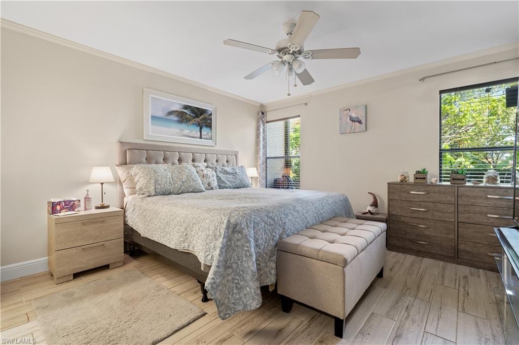 Bedroom featuring ornamental molding, light wood-type flooring, and ceiling fan