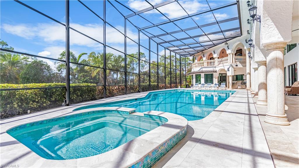 Combined pool / hot tub with a lanai, a patio area, and a balcony