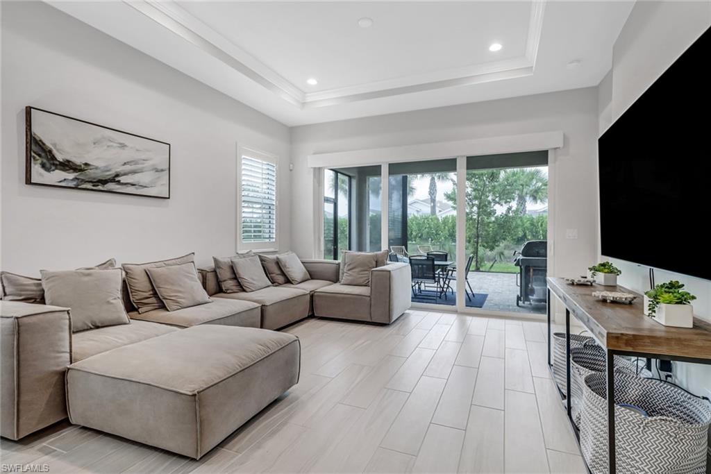 Living room with a wealth of natural light, a tray ceiling, and recessed lighting