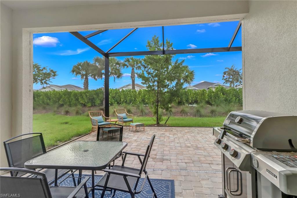 View of patio featuring outdoor dining space, a lanai, area for grilling, and a grill