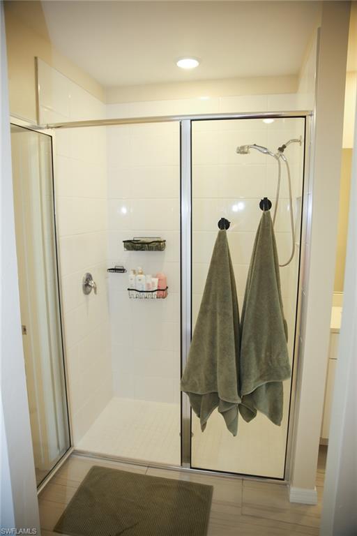 Bathroom featuring a shower stall, recessed lighting, vanity, and light wood-style floors