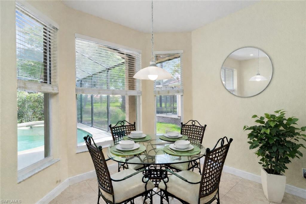 Large windows in the breakfast room offer views of the pool and golf course beyond