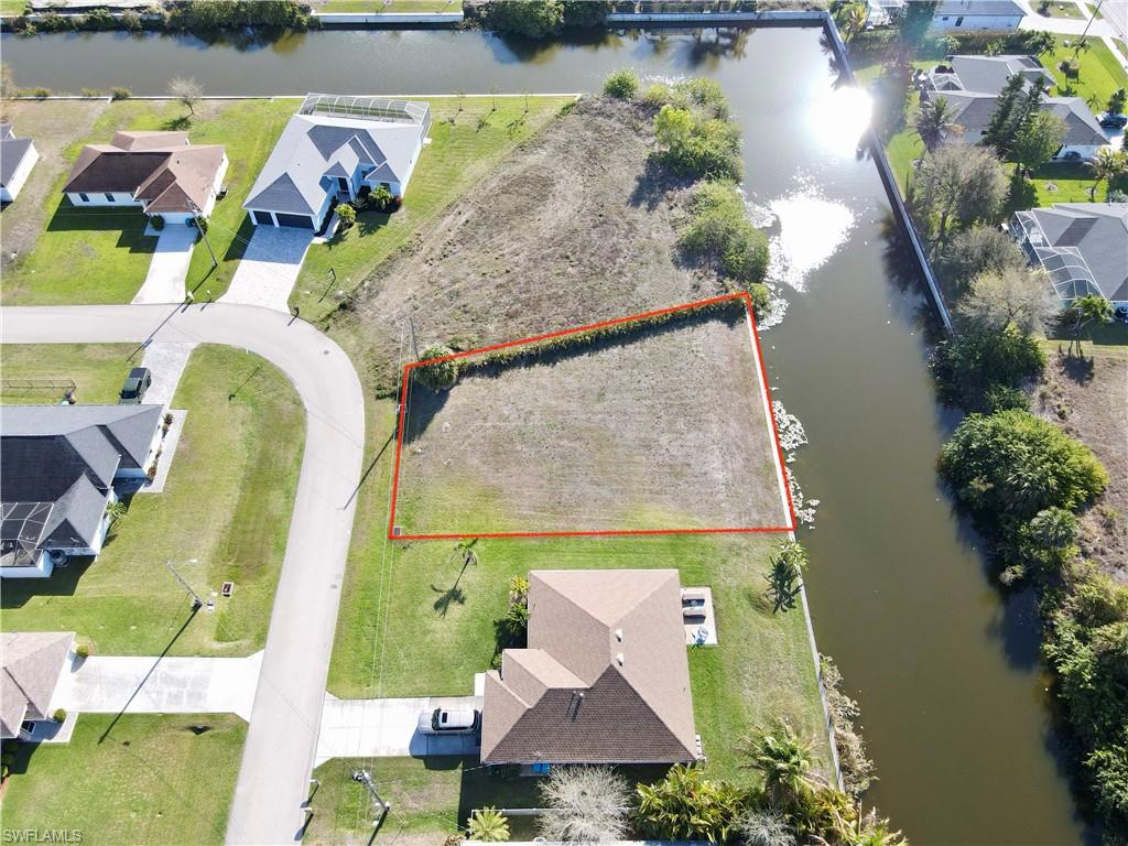 Aerial perspective of suburban area featuring a nearby body of water and property boundaries highlighted