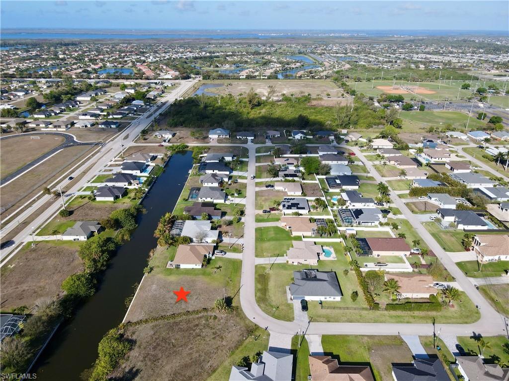 Aerial view of property and surrounding area with nearby suburban area and a large body of water