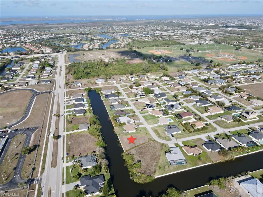 Aerial view of property and surrounding area with a nearby body of water and nearby suburban area