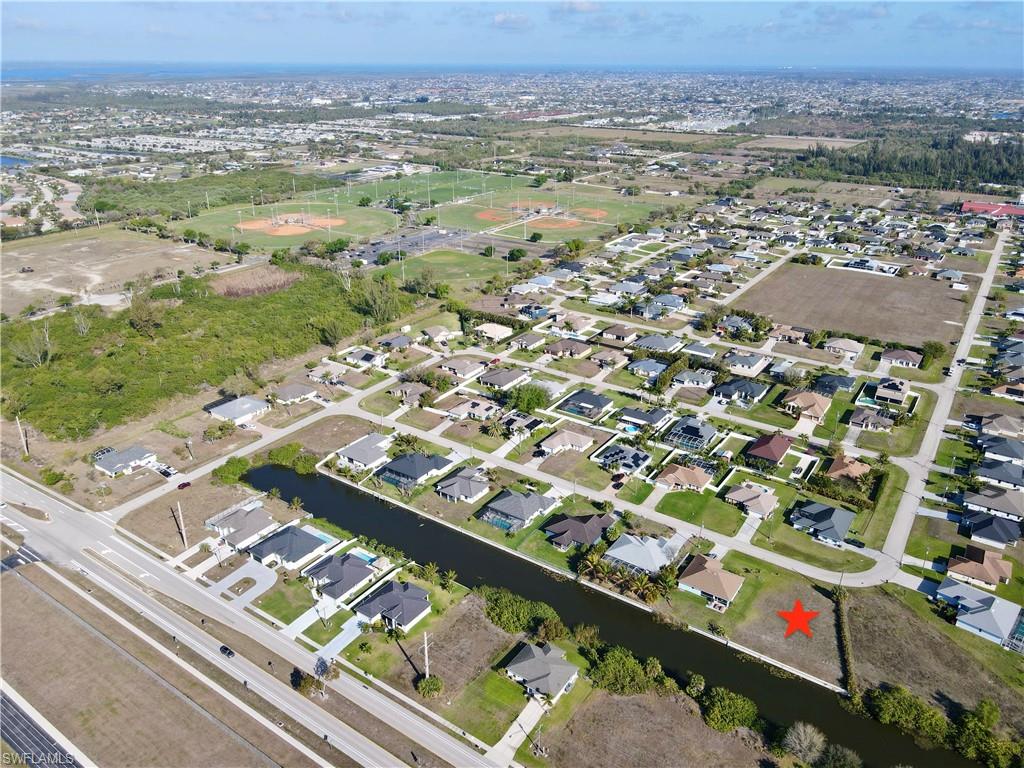 Aerial overview of property's location featuring a nearby body of water and nearby suburban area