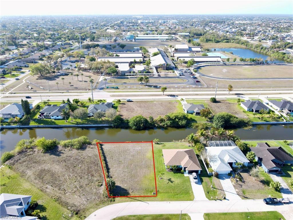 Aerial view of residential area with property parcel outlined and a nearby body of water