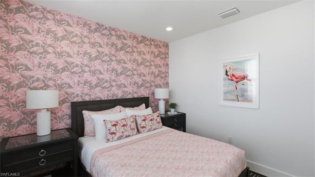 Bedroom featuring wallpapered walls, an accent wall, and recessed lighting - Virtually Edited