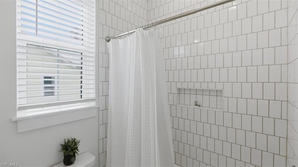 Bathroom featuring a stall shower and toilet - Virtually Edited