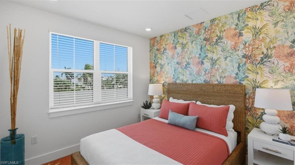 Bedroom with an accent wall, wallpapered walls, recessed lighting, and wood finished floors - Virtually Edited