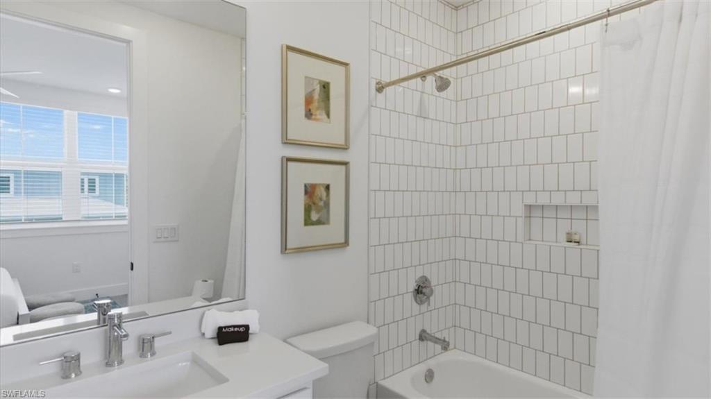 Bathroom with shower / bath combination with curtain, vanity, and ensuite bathroom - Virtually Edited