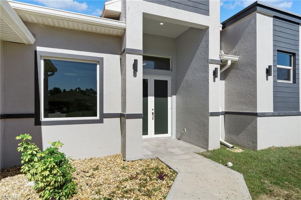 View of exterior entry with french doors and stucco siding