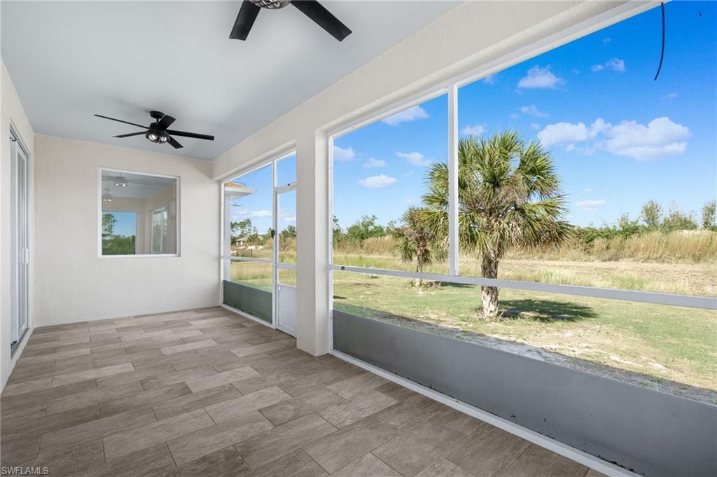 Unfurnished sunroom featuring ceiling fan