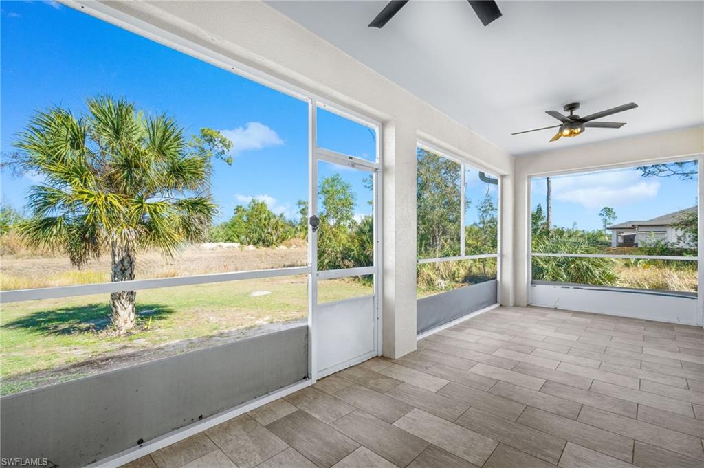 Unfurnished sunroom featuring a ceiling fan