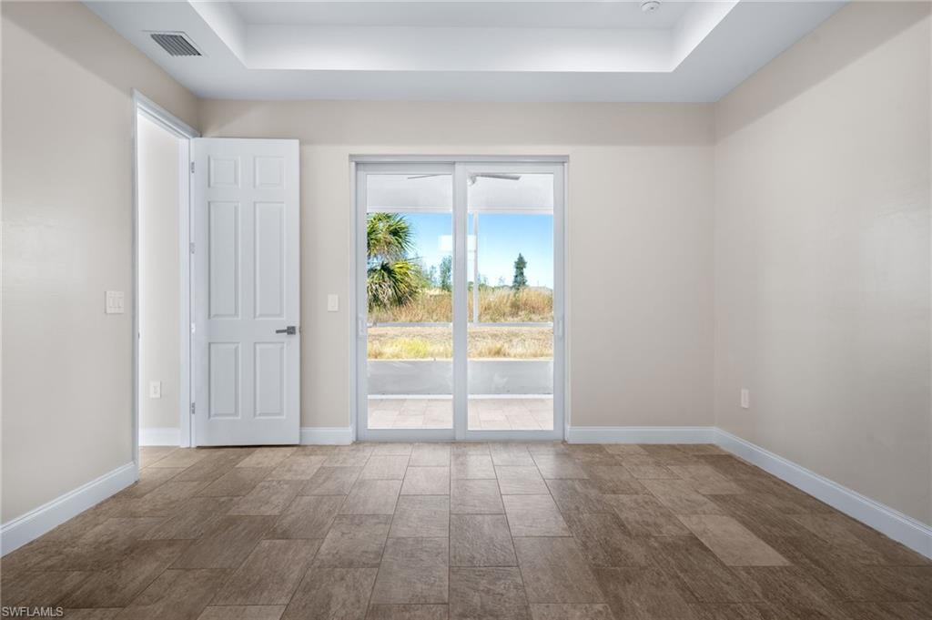 Empty room featuring a raised ceiling and wood tiled floors