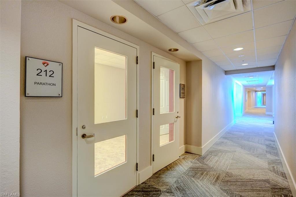 Common area Hallway featuring commercial light carpet, a drop ceiling, and recessed lighting