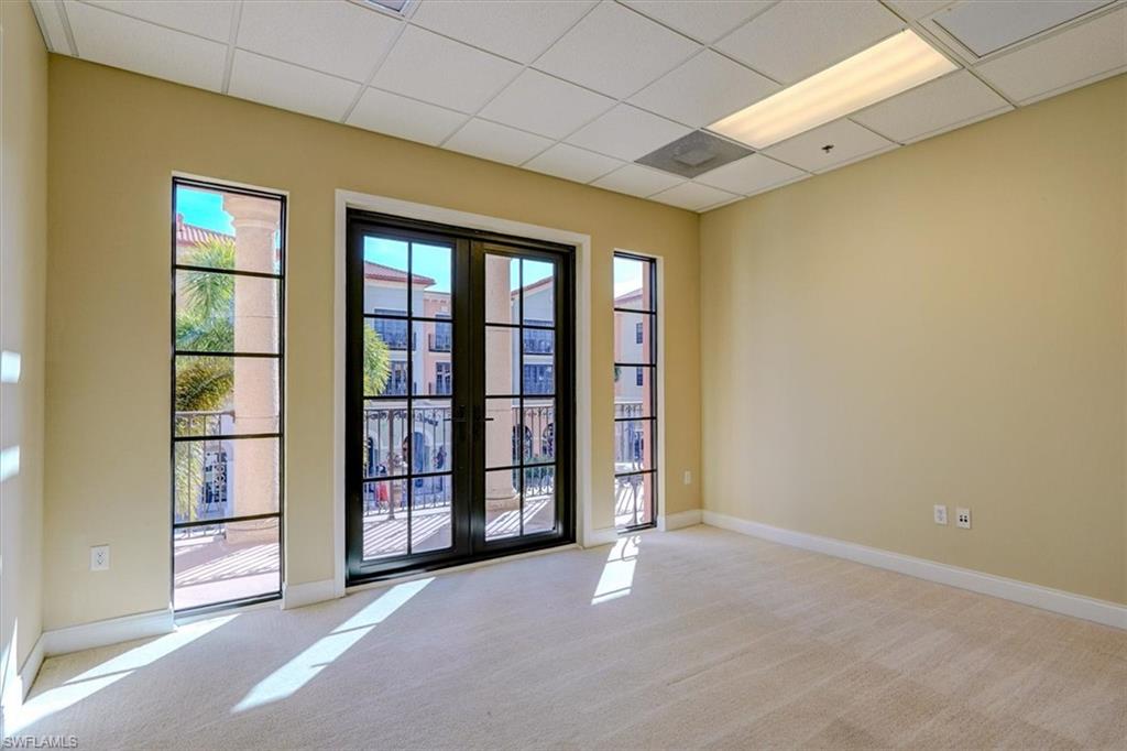 Office featuring a drop ceiling, light colored carpet, and french doors